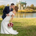 St. Louis wedding photographer captures a bride and groom kissing in front of a serene pond near the Muny in St. Louis' Forest Park.