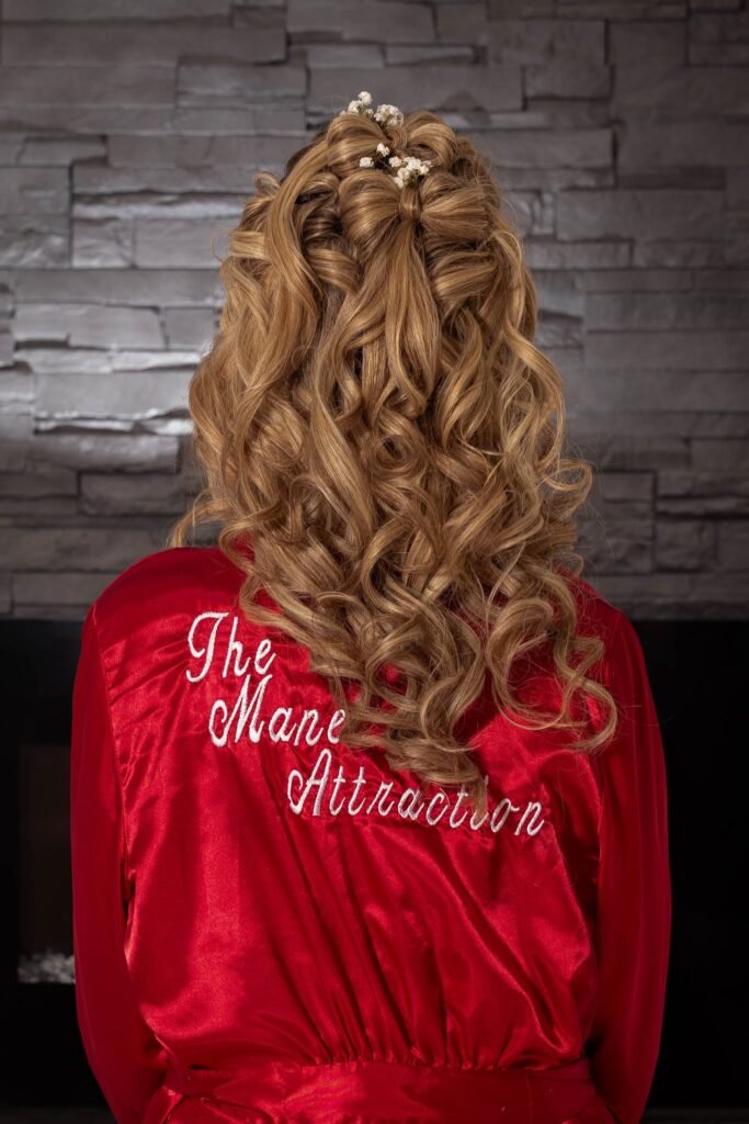 Bridal hair styled by Carla at The Mane Attraction Collinsville Illinois featuring sculptural hair bow with baby's breath and cascading curls