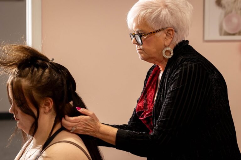 Carla of The Mane Attraction Hair Studio in Collinsville Illinois styling bridal hair at a wedding bridal show, over 50 years of experience