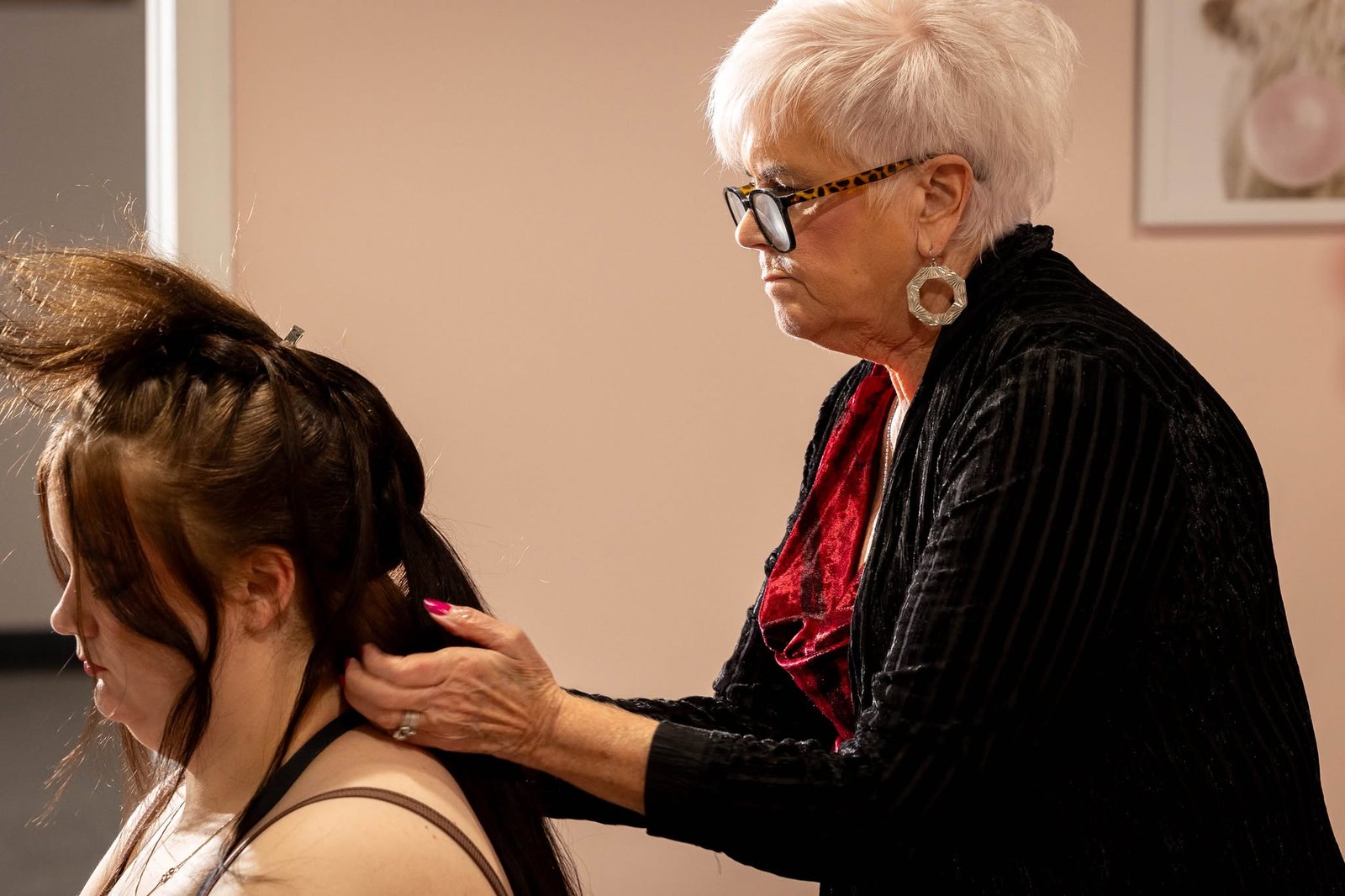 Carla of The Mane Attraction Hair Studio in Collinsville Illinois styling bridal hair at a wedding bridal show, over 50 years of experience