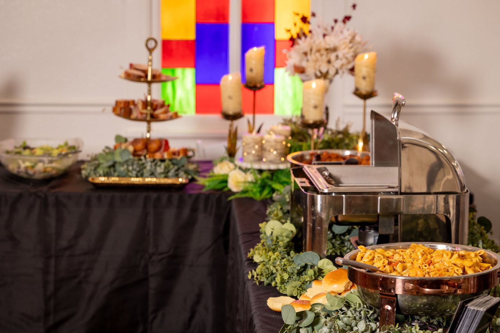 Food Dude Catering buffet setup with copper chafing dishes, eucalyptus garland, and tiered display at a Southern Illinois wedding bridal show